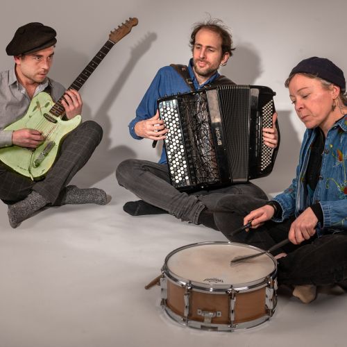 Le trio de musicien Kordacor" assis au sol en train de jouer.