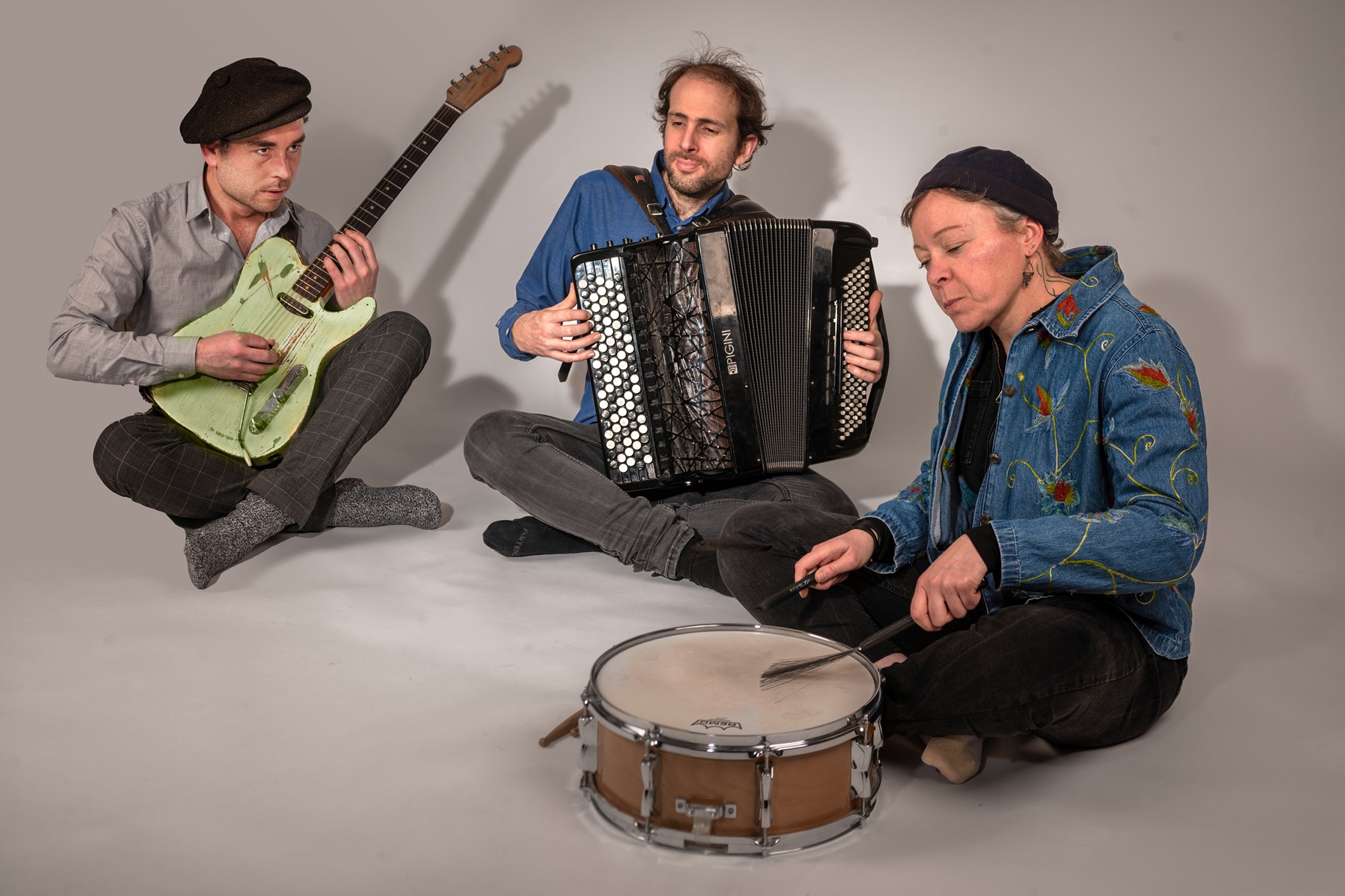 Le trio de musicien Kordacor" assis au sol en train de jouer.