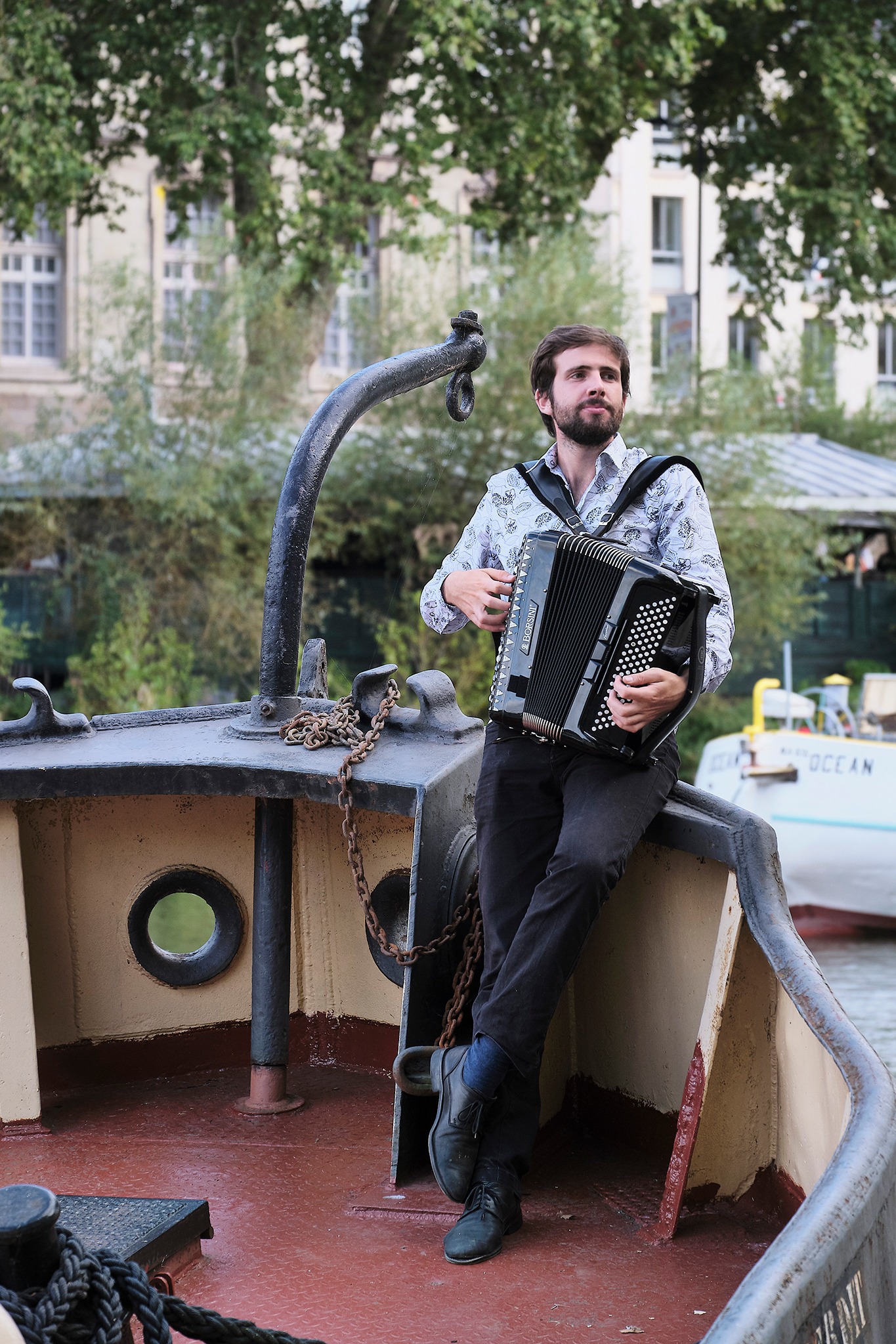 Pamhpile et son accordéon, jouant addossé à la rambarde d'un bateau au RDV de l'erdre