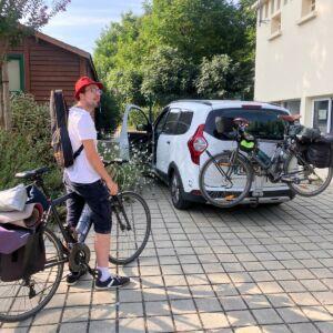 Pamphile devant la voiture suiveuse au camping.