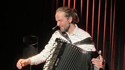 Pamphile sur scène dans dualités avec son accordéon et son pédale-board.