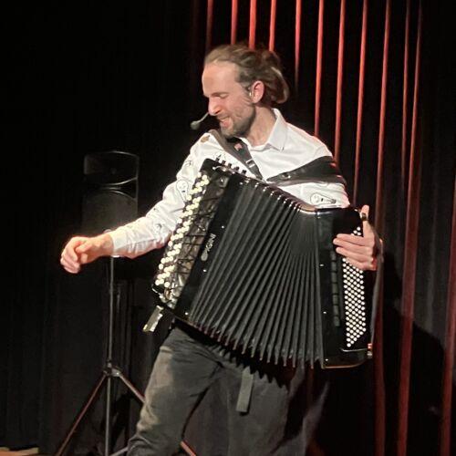 Pamphile sur scène dans dualités avec son accordéon et son pédale-board.